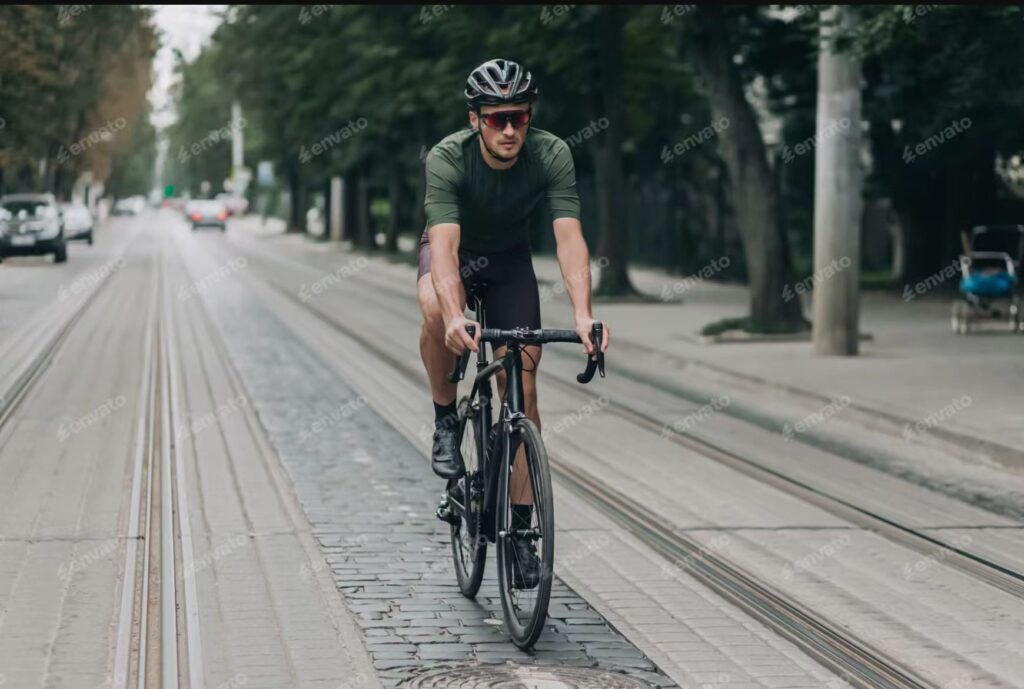 Man cycling on a city street lined with trees