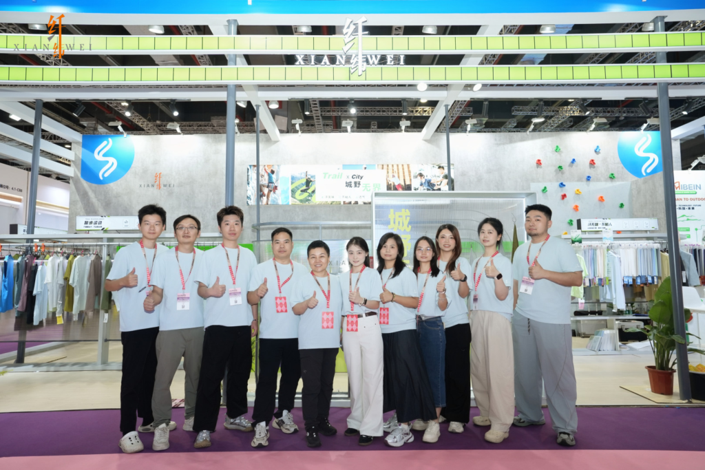 Mibein team group photo giving a thumbs-up at their exhibition booth at Intertextile Shanghai 2026